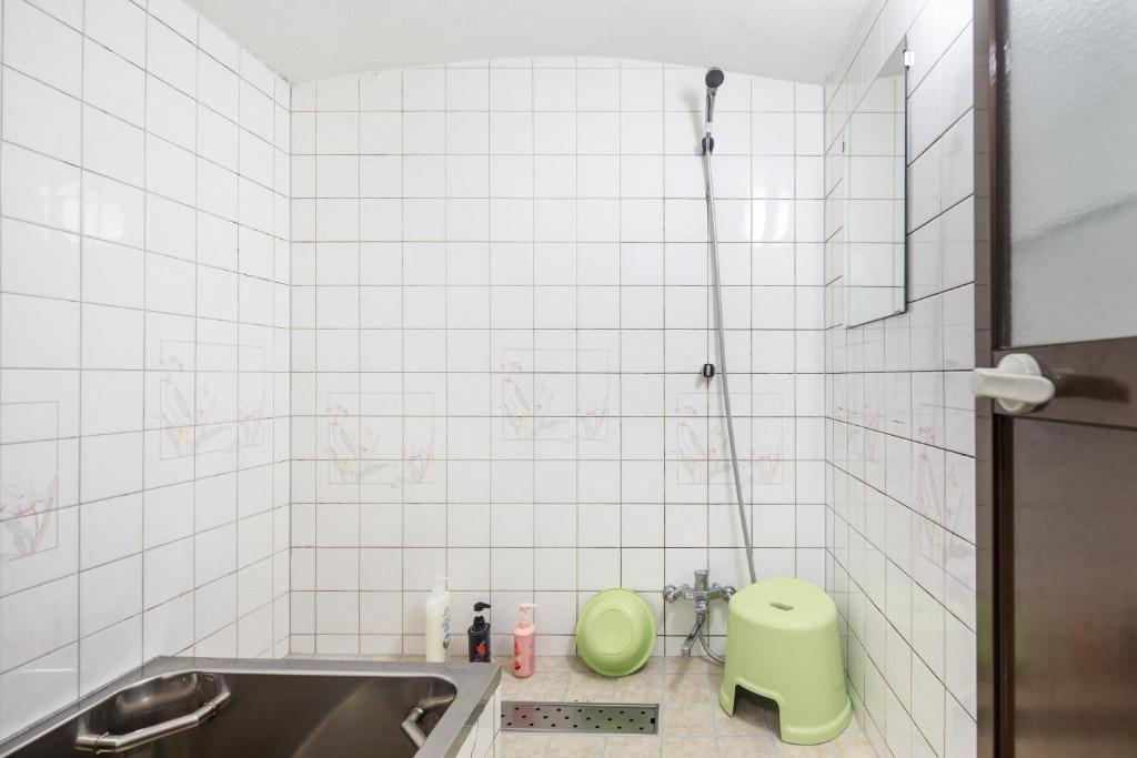 a bathroom with a shower with a green toilet in it at Yadoya Hiraiwa private ryokan in Kyoto