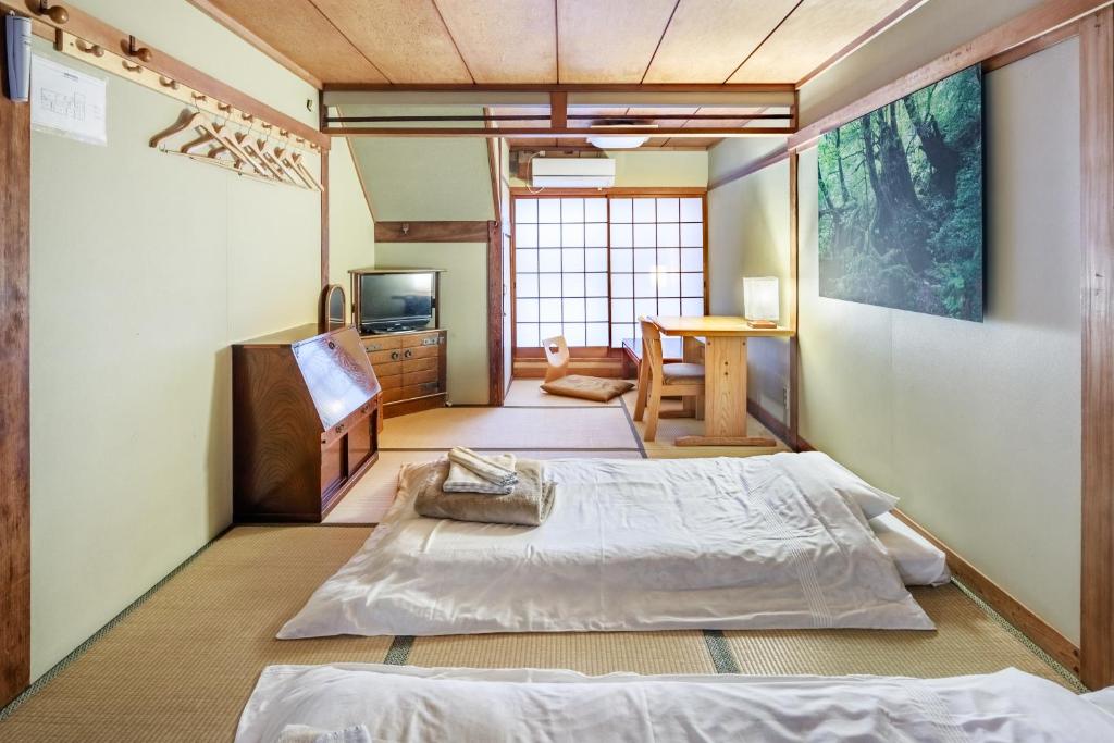 a room with a bed and a tv in it at Yadoya Hiraiwa private ryokan in Kyoto