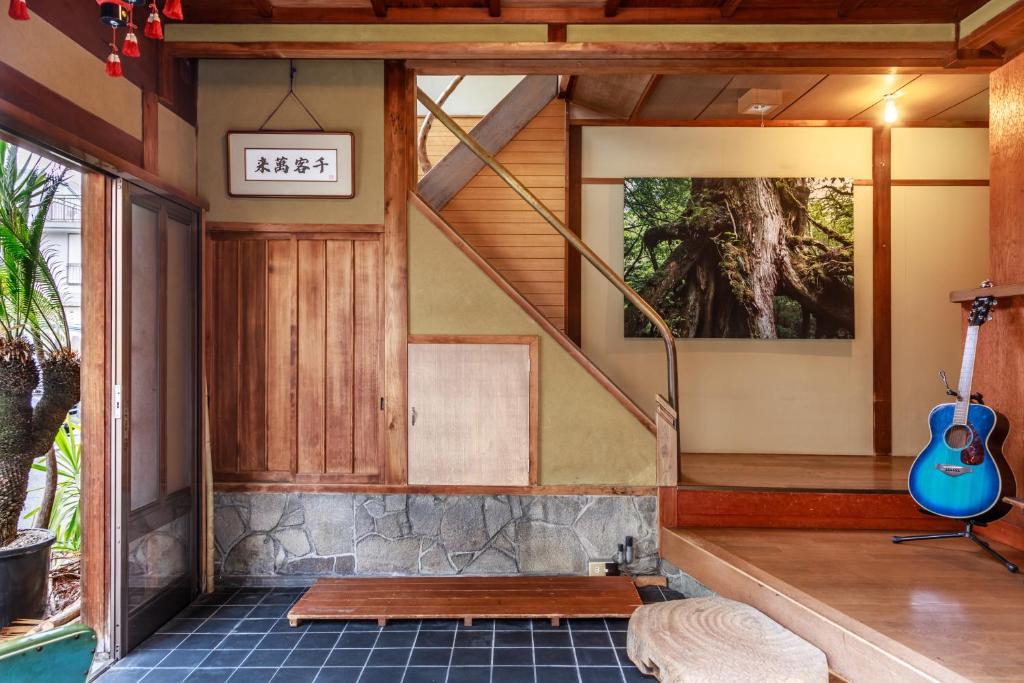a room with a staircase and a guitar on the floor at Yadoya Hiraiwa private ryokan in Kyoto