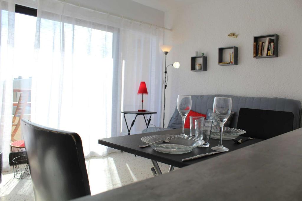 - un salon avec une table et des verres à vin dans l'établissement Appartement studio PORT LA NOUVELLE PN590-014, à Port-la-Nouvelle