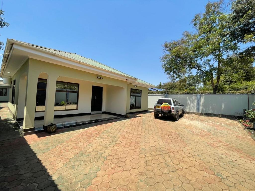 un coche aparcado delante de una casa en Emmalanta Safaris House, en Arusha
