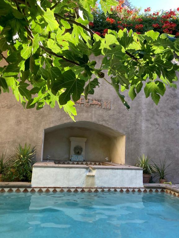 une piscine avec une fontaine en face d'un bâtiment dans l'établissement Mas de silvacane, à La Roque-dʼAnthéron