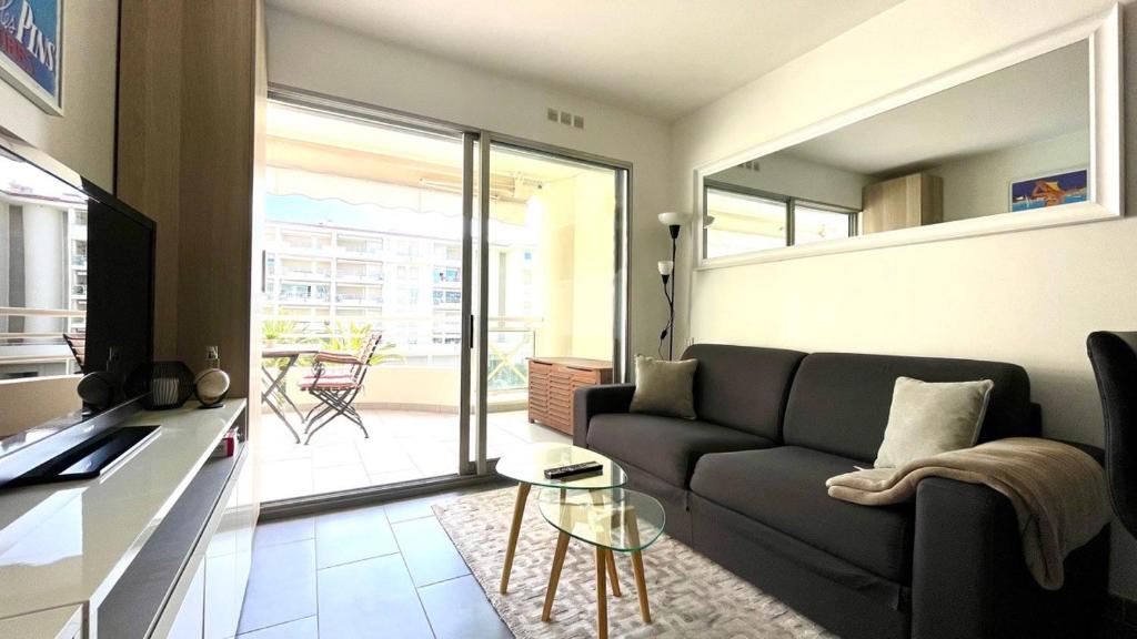 un salon avec un canapé et une table dans l'établissement Incroyable vue mer et accès plage !, à Antibes