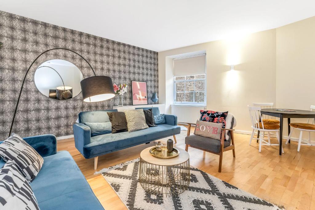 エディンバラにあるBeautiful Designer 2 Bed 2 Bath Old Town - Parkingの青いソファとテーブルのあるリビングルーム