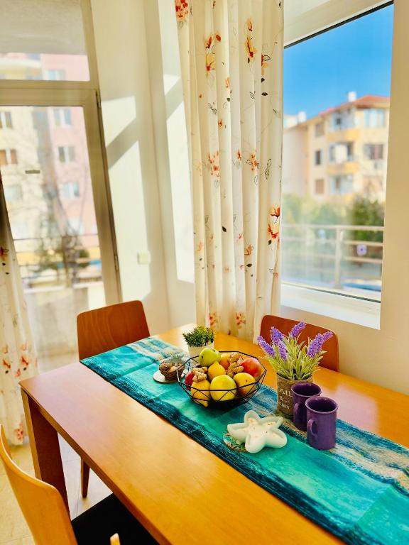 a wooden table with a bowl of fruit on it at Charming 2-bed flat with pool view in Sunny Beach, Bulgaria in Sunny Beach
