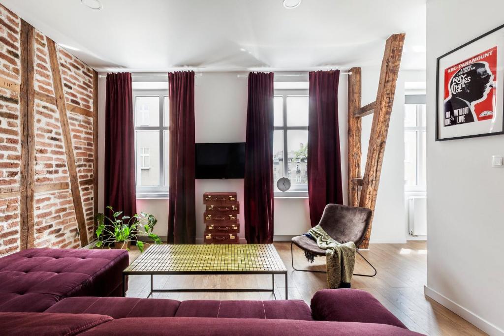 a living room with a purple couch and a chair at Apartamenty Cinema in Poznań