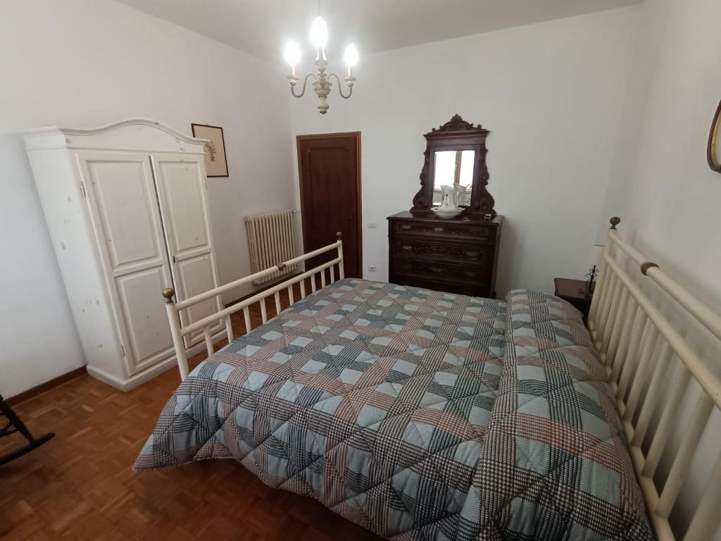 Un dormitorio con una cama, una cómoda y un espejo. en Casa SoleLuna, en Siena
