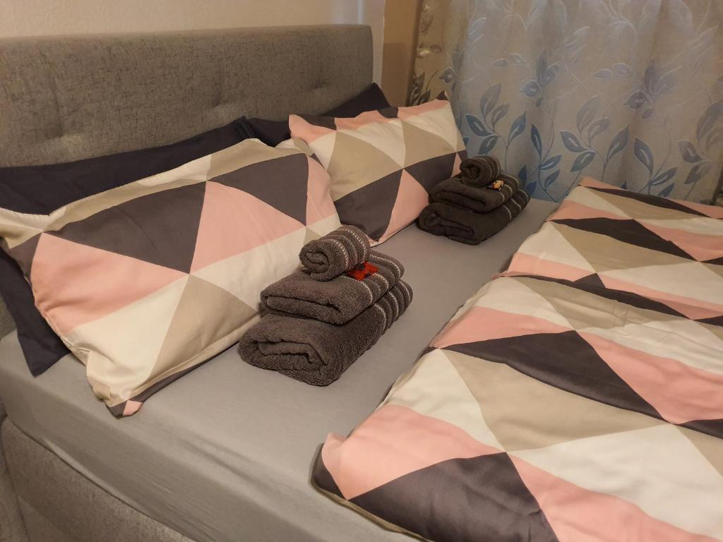 a bed with two pillows and towels on it at Schönes Modernes Apartment in der Nähe vom Bahnhof in Tübingen