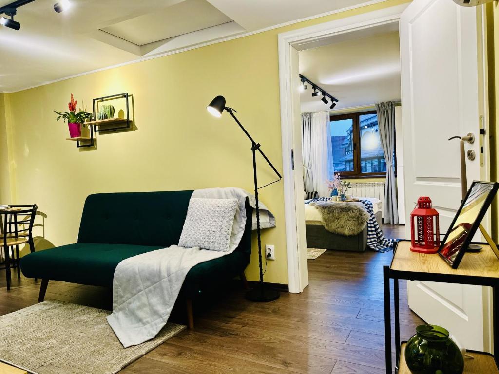 a living room with a green couch and a table at 5 to Stay near Legends of Bran in Bran