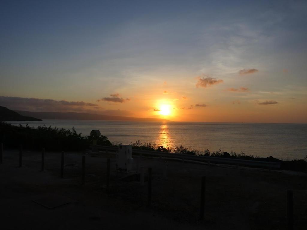 a sunset over the ocean with the sun in the sky at The Sunset in Flying Fish Cove