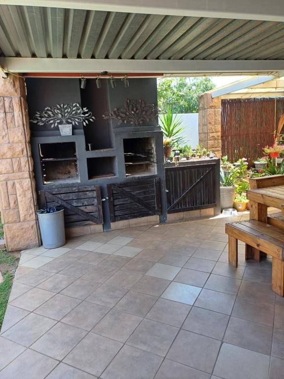 a patio with awning and a wooden bench at Orchard Guesthouse in Bloemfontein