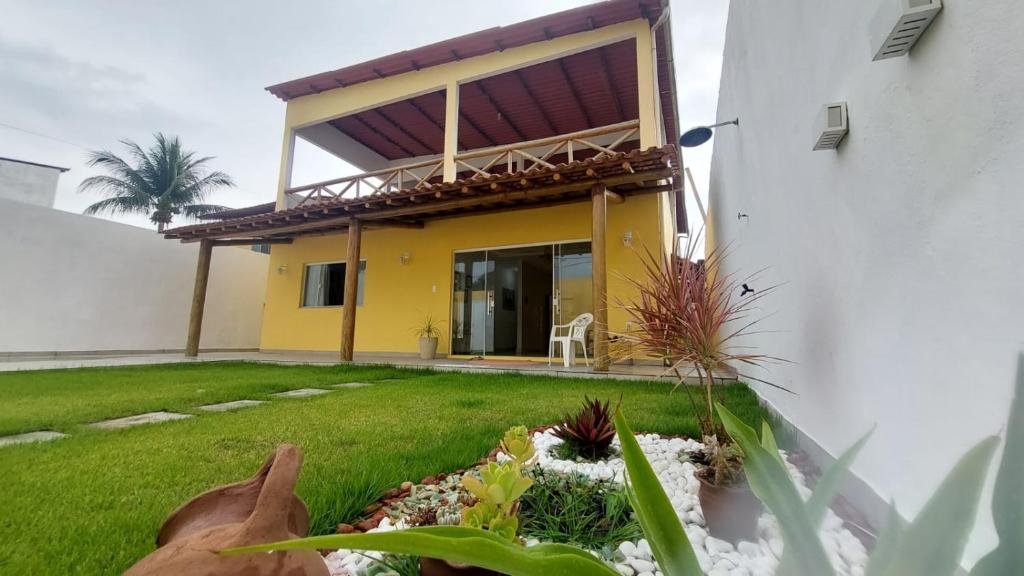 a yellow and white house with a yard at Cantinho do sossego in Ilhéus