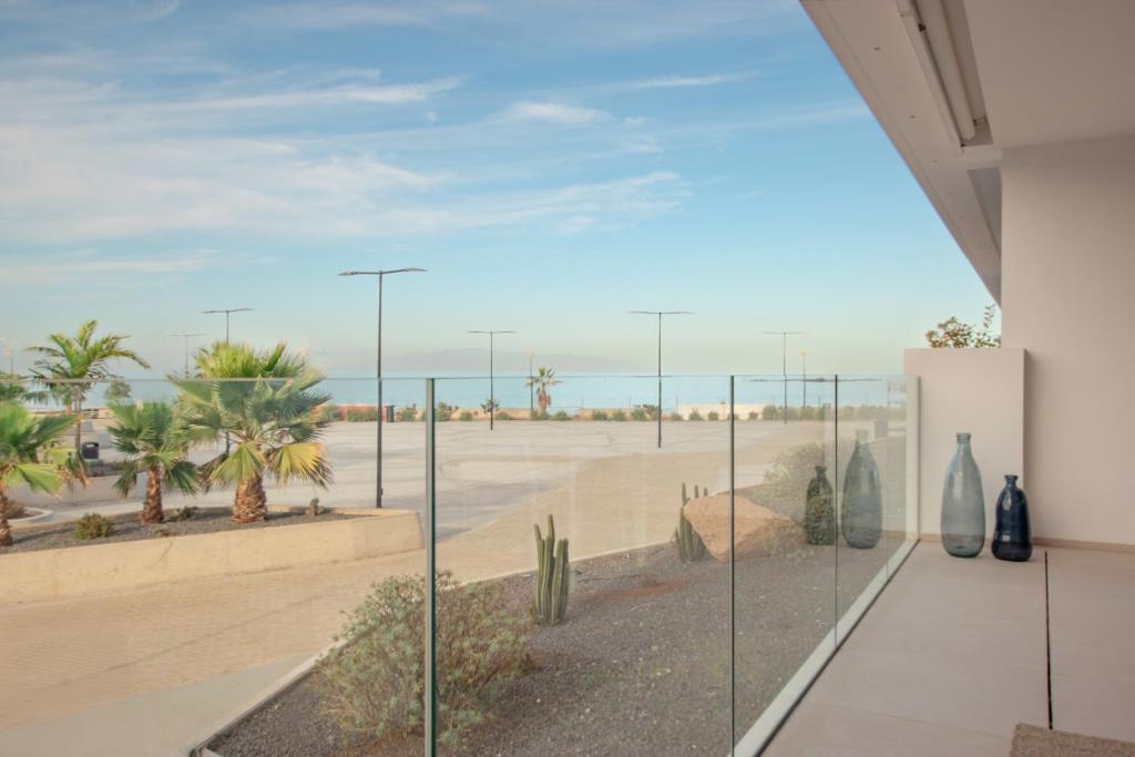 a room with a view of the beach through glass at Infinity 0-2 LUXE PARTIAL SEA VIEW 2B in Arona