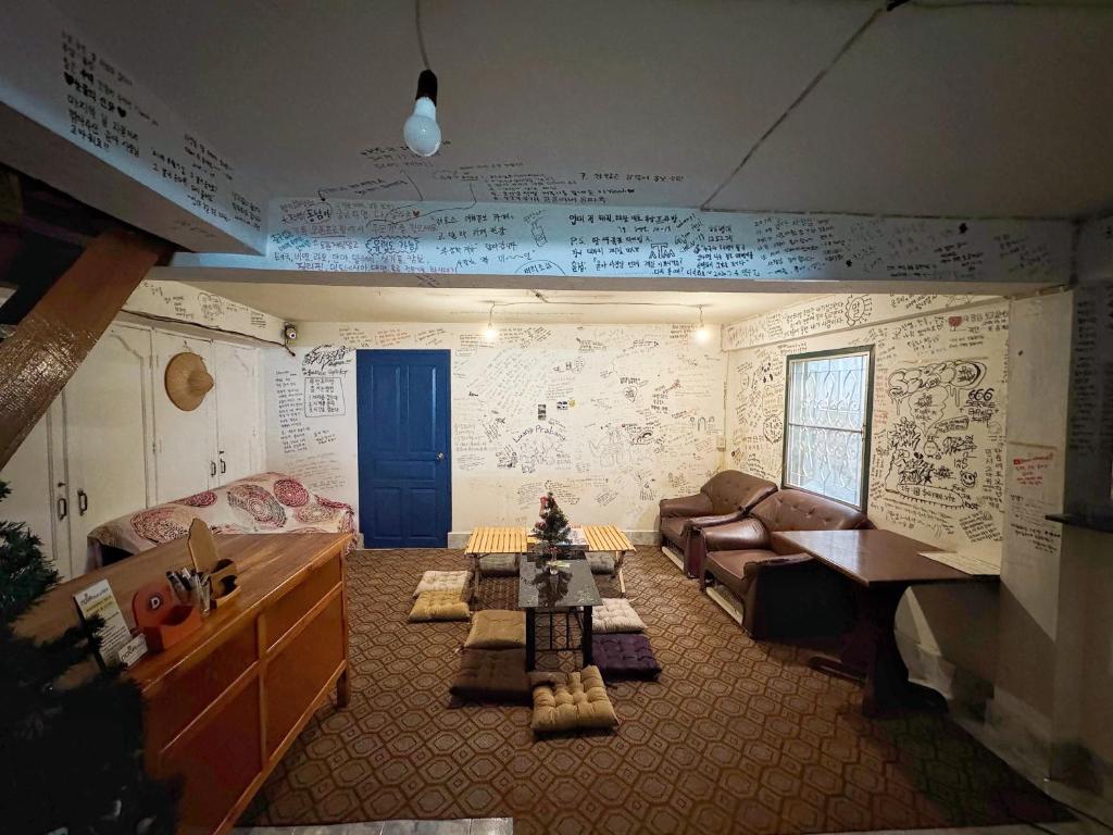 a living room with drawings on the walls at Aloha LuangPrabang Hostel Capsule in Luang Prabang