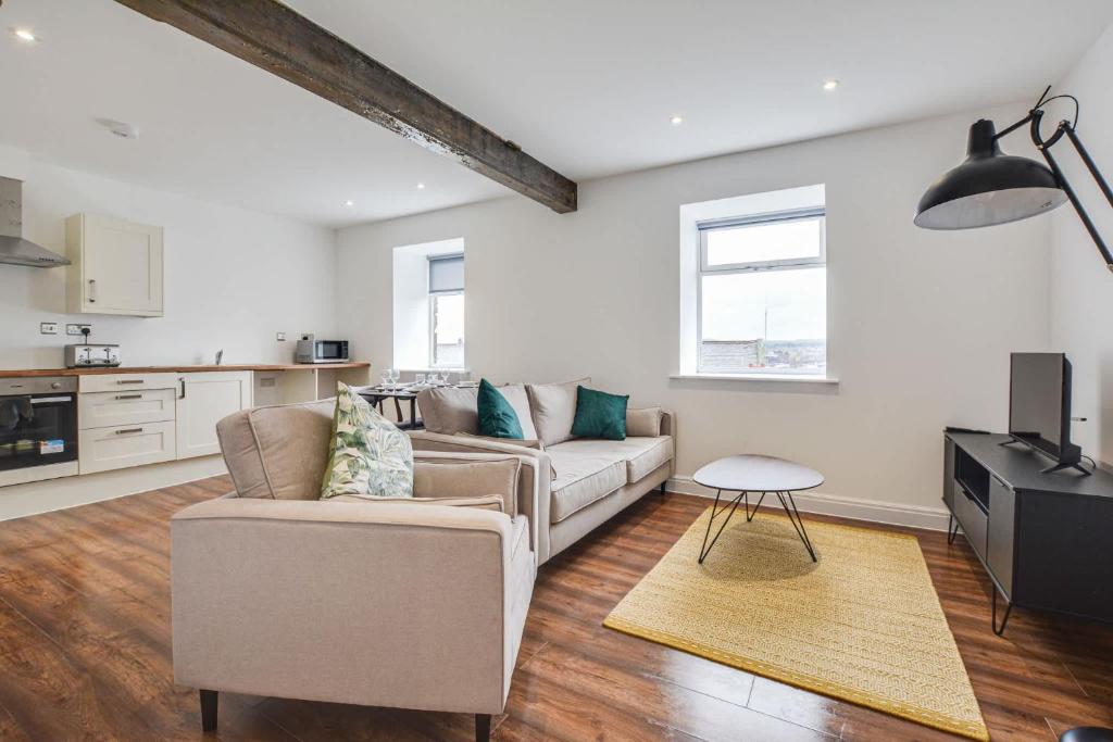 a living room with a couch and a table at Host & Stay - Canalside Lofts Apartment in Burnley