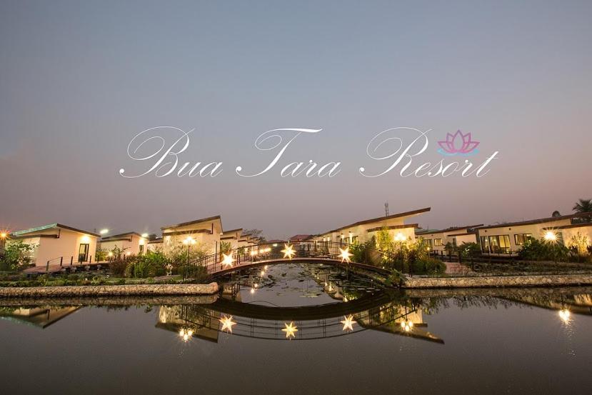 eine Brücke über einen Fluss mit Häusern und Gebäuden in der Unterkunft Bua Tara Resort in Nong Prue