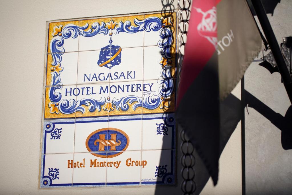 a sign for a hotel monkey group on a wall at Hotel Monterey Nagasaki in Nagasaki