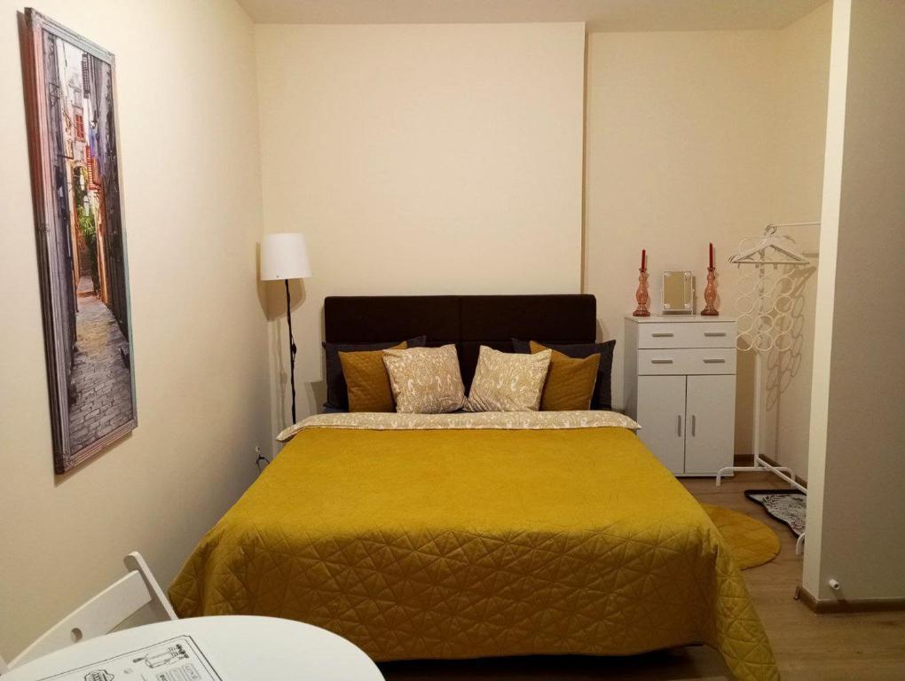 a bedroom with a bed with a yellow blanket at Solidarnosci155GuestRooms in Warsaw