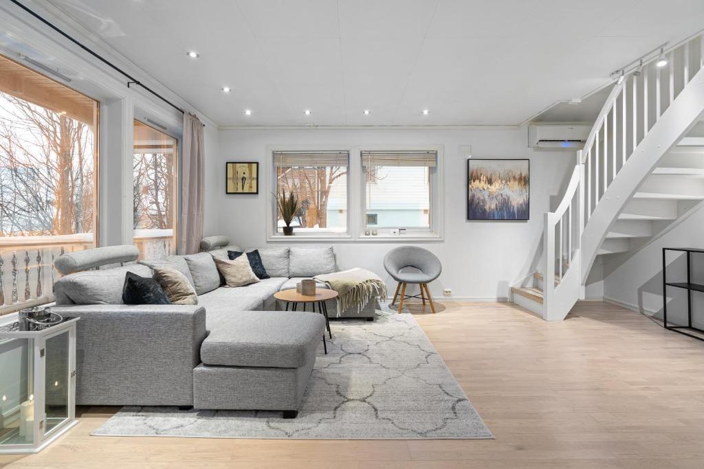 a living room with a couch and a staircase at Near Downtown - Large Beds - Free Parking in Tromsø
