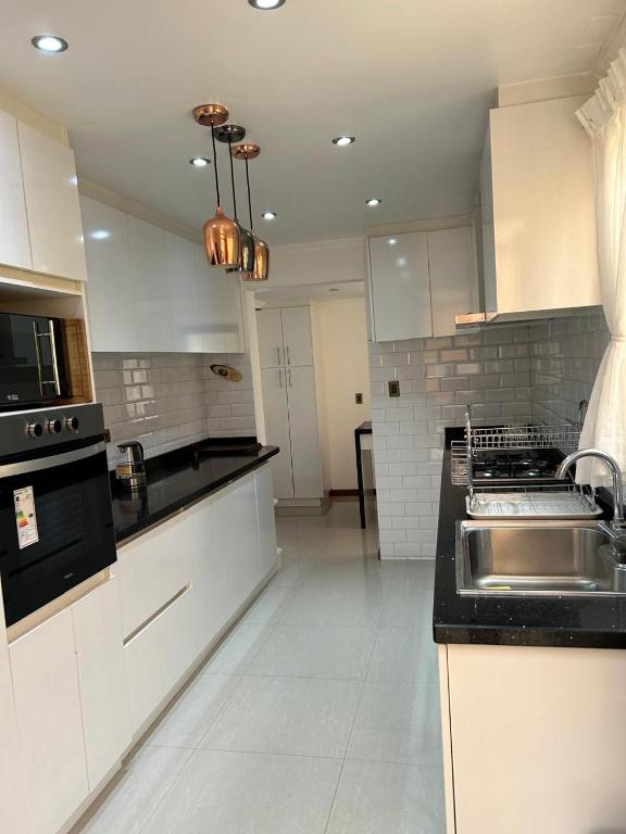 a kitchen with white cabinets and a sink at Casa Condominio la Bahía in Coquimbo