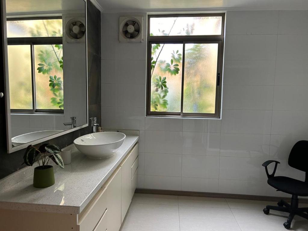 ein Badezimmer mit einem Waschbecken, einem Spiegel und einem Stuhl in der Unterkunft Casa Condominio la Bahía in Coquimbo