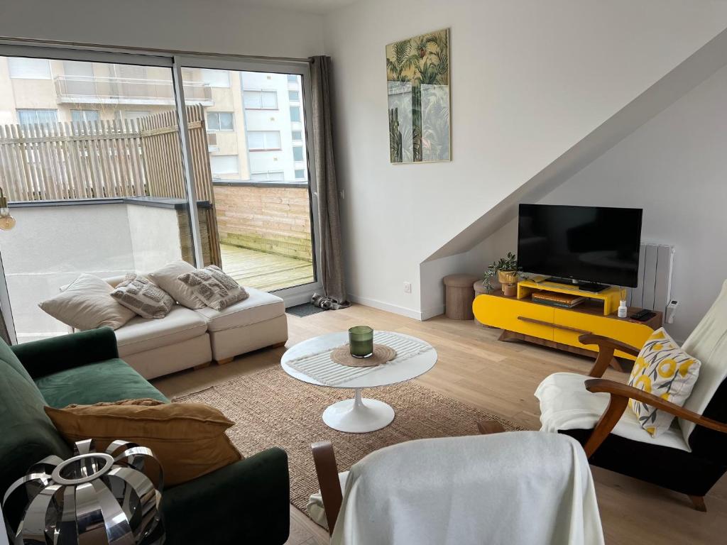 un salon avec un canapé et une télévision dans l'établissement Grand Chelem 2, à Le Touquet-Paris-Plage