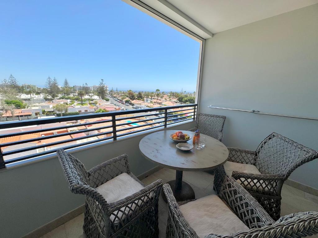 a balcony with a table and chairs and a window at Luxury 2 Bedrooms Ocean View Iguazu in Playa del Ingles