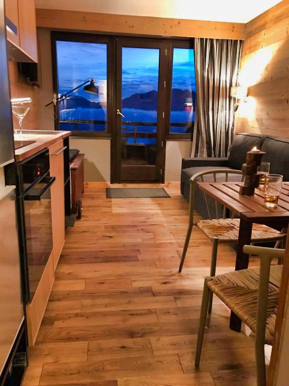 une cuisine et un salon avec une table et un canapé dans l'établissement Studio avec coin montagne et belle vue panoramique, à Huez