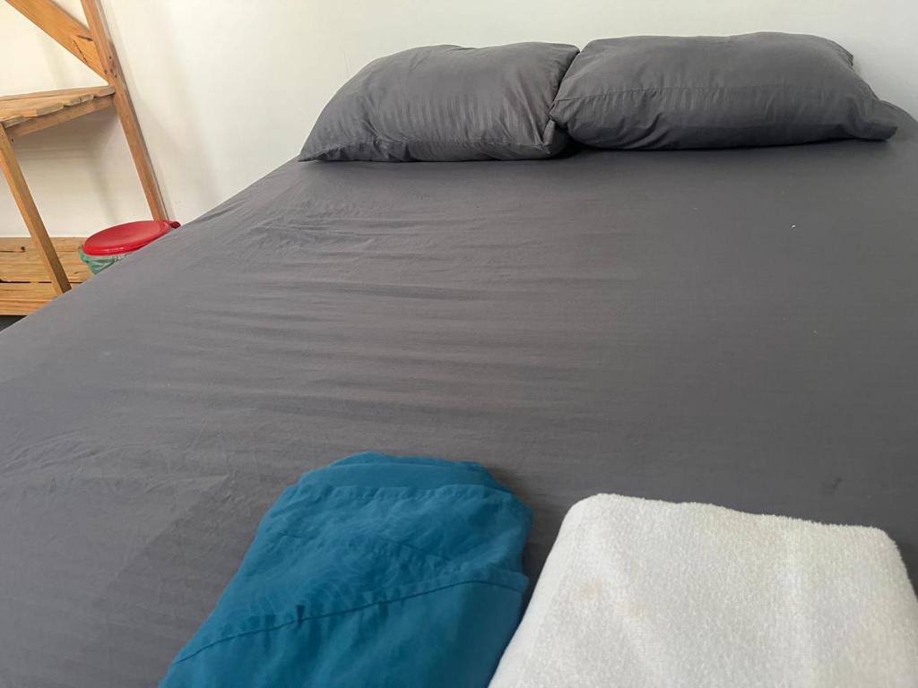 a bed with a blue and gray pillow on it at Habitación cerca de la playa 204 in Cartagena de Indias