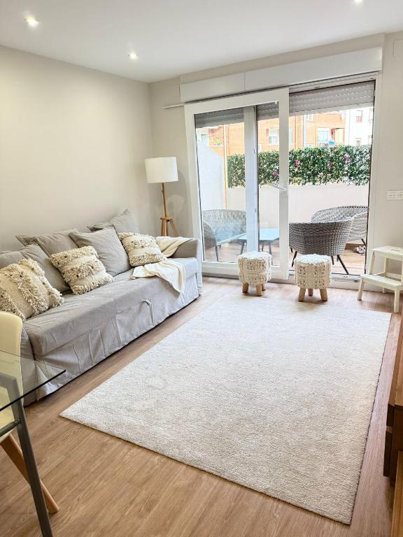 a living room with a couch and a rug at Reformado Centro con Terraza in Castro-Urdiales