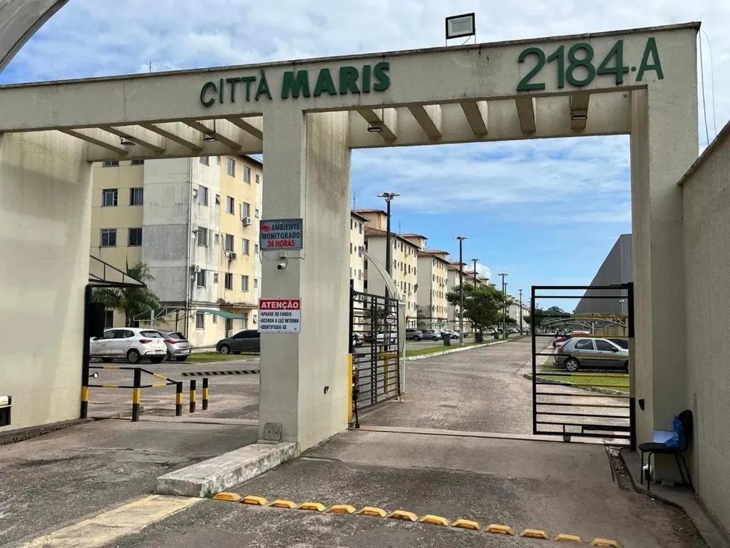 an open gate to a parking lot with cars at Condomínio City Maris in Marituba