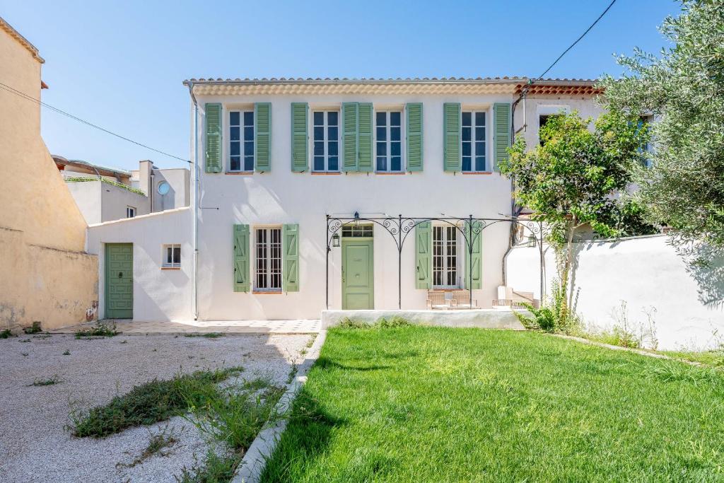 une vieille maison avec des portes vertes et une cour dans l'établissement Maison entre Port et Calanques, à La Ciotat