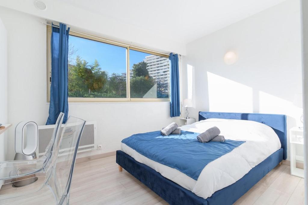 une chambre avec un lit et une grande fenêtre dans l'établissement Studio en bord de plage, à Villeneuve-Loubet