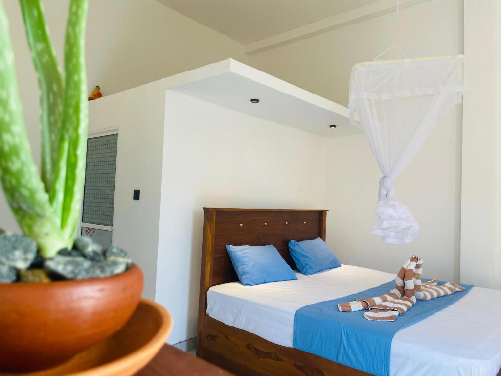 a bedroom with two beds and a potted plant at The Pearl Villa Ahangama in Ahangama