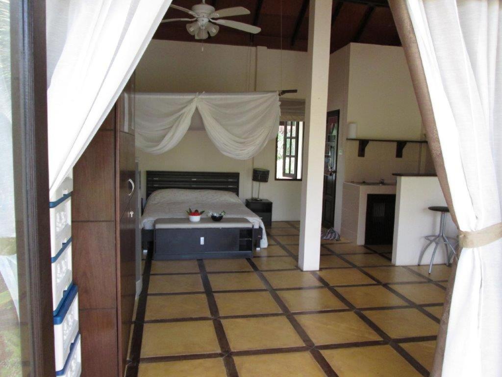 Un dormitorio con una cama con ventilador de techo. en Baan Rim Tarn B&B, en Takua Pa