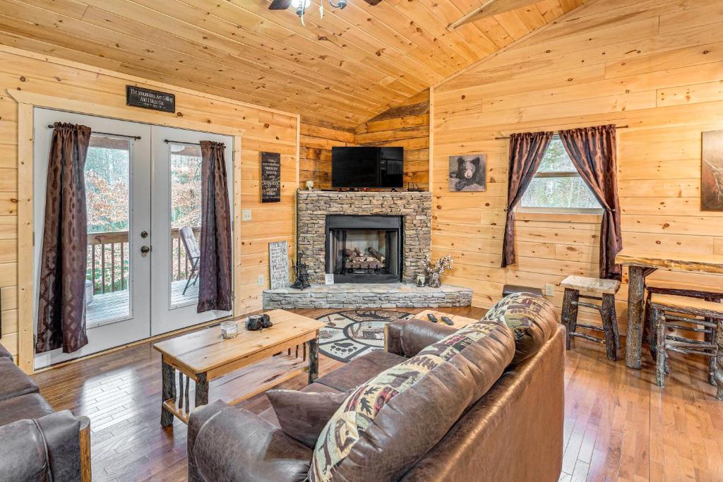 a living room with a couch and a fireplace at Deck and Fire Pit Smoky Mountain Cabin Hideaway! in Murphy