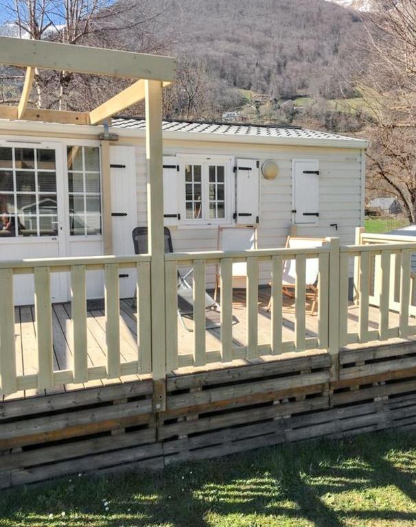 une maison avec un porche et une clôture dans l'établissement Bungalow paisible à Cauterets, à Cauterets