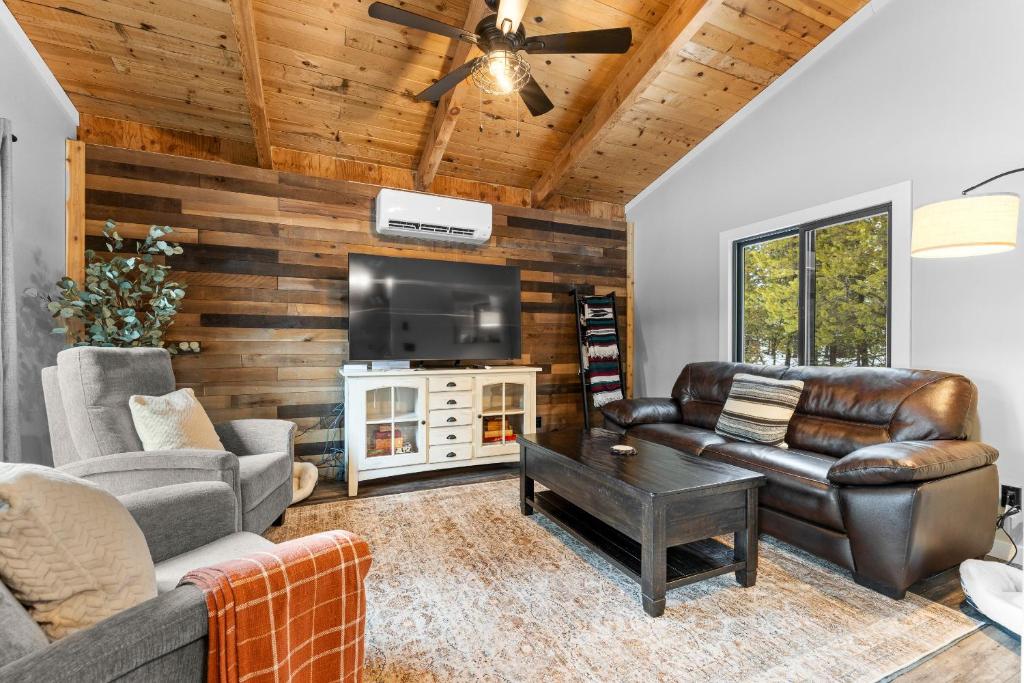 Il comprend un salon doté d'un mobilier en cuir et d'une télévision à écran plat. dans l'établissement Blue Haven - Wooded, pet friendly home w/ trailer parking, AC, and deck, à Donnelly