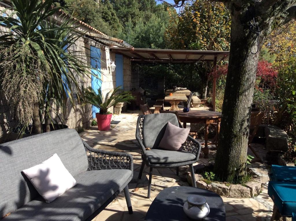 une terrasse avec deux chaises, un canapé et une table dans l'établissement Maison A Tigliola, à Porto-Vecchio