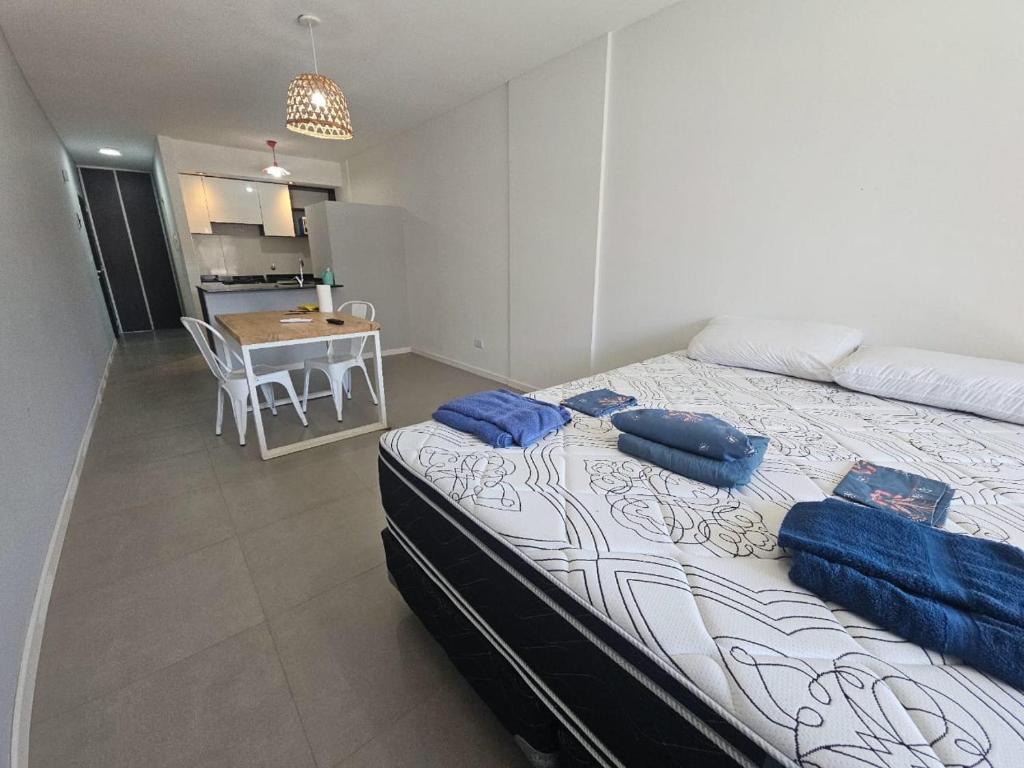 a bedroom with a bed with blue pillows on it at Alquiler Temporario Rosario 22 in Rosario