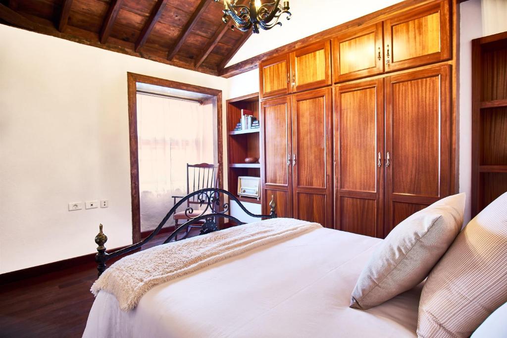 a bedroom with a bed with wooden cabinets and a window at El Convento II, tranquilidad y vistas únicas in San Andres y Sauces