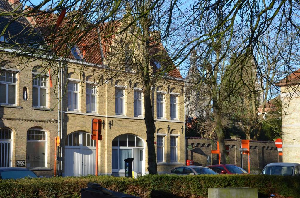 un gran edificio de ladrillo con coches estacionados frente a él en B&B Jacob20, en Ypres