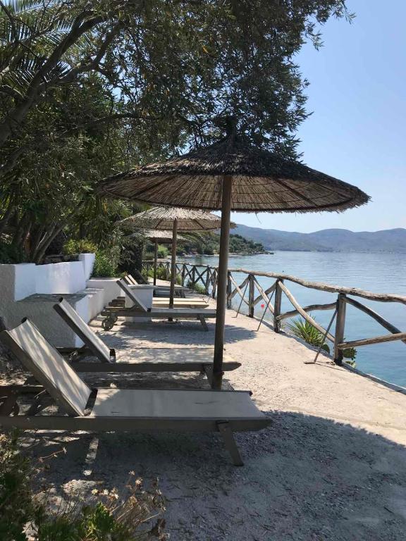 a group of chairs and an umbrella on the beach at Pounda Paou in Metókhion