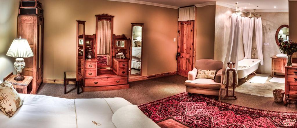 una camera con letto, vasca e sedia di The FarSide Country Manor a Nottingham Road