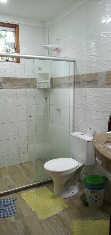 a bathroom with a toilet and a glass shower at CHALÉ LUZIMAREs 01 in Ilhéus