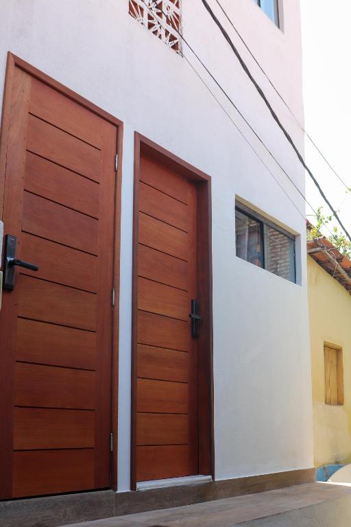two wooden doors on the side of a building at Brisa - Praia da Pipa in Pipa