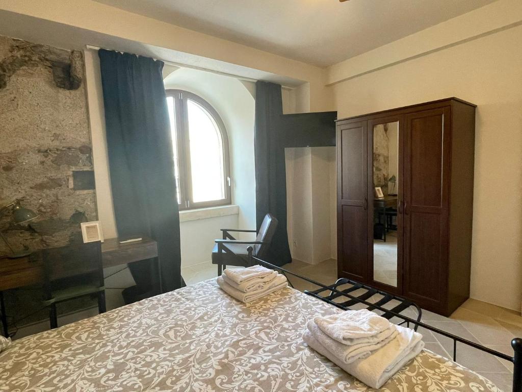 a bedroom with a bed with two towels on it at Castello D'Alcontres Guest House 3 stelle in Nizza di Sicilia