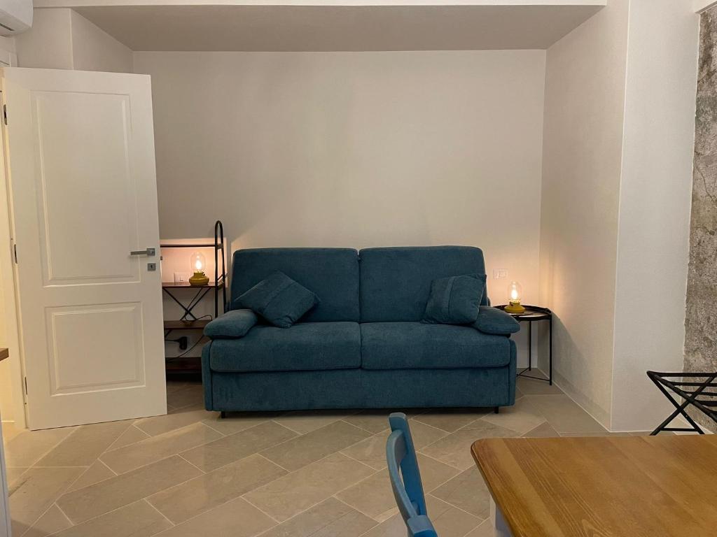 a living room with a blue couch and a table at Castello D'Alcontres Guest House 3 stelle in Nizza di Sicilia