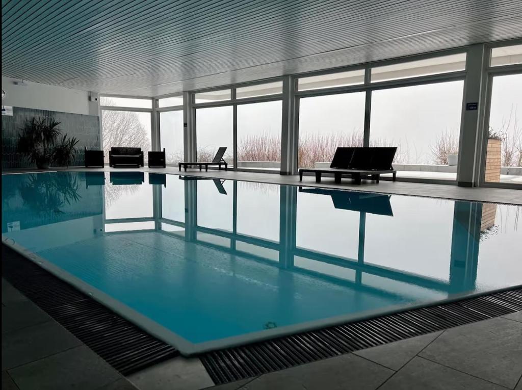 a large swimming pool in a building with blue water at Ferienwohnung Geyersberg Freyung in Freyung