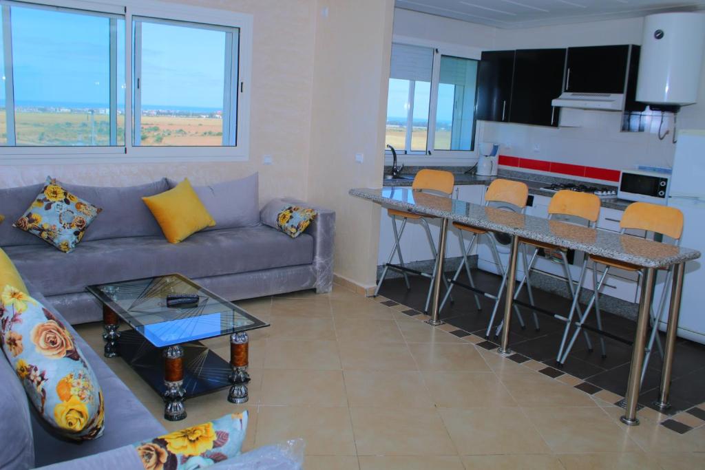 una sala de estar con un sofá y una mesa en BOUZNIKA AJ, en Bouznika